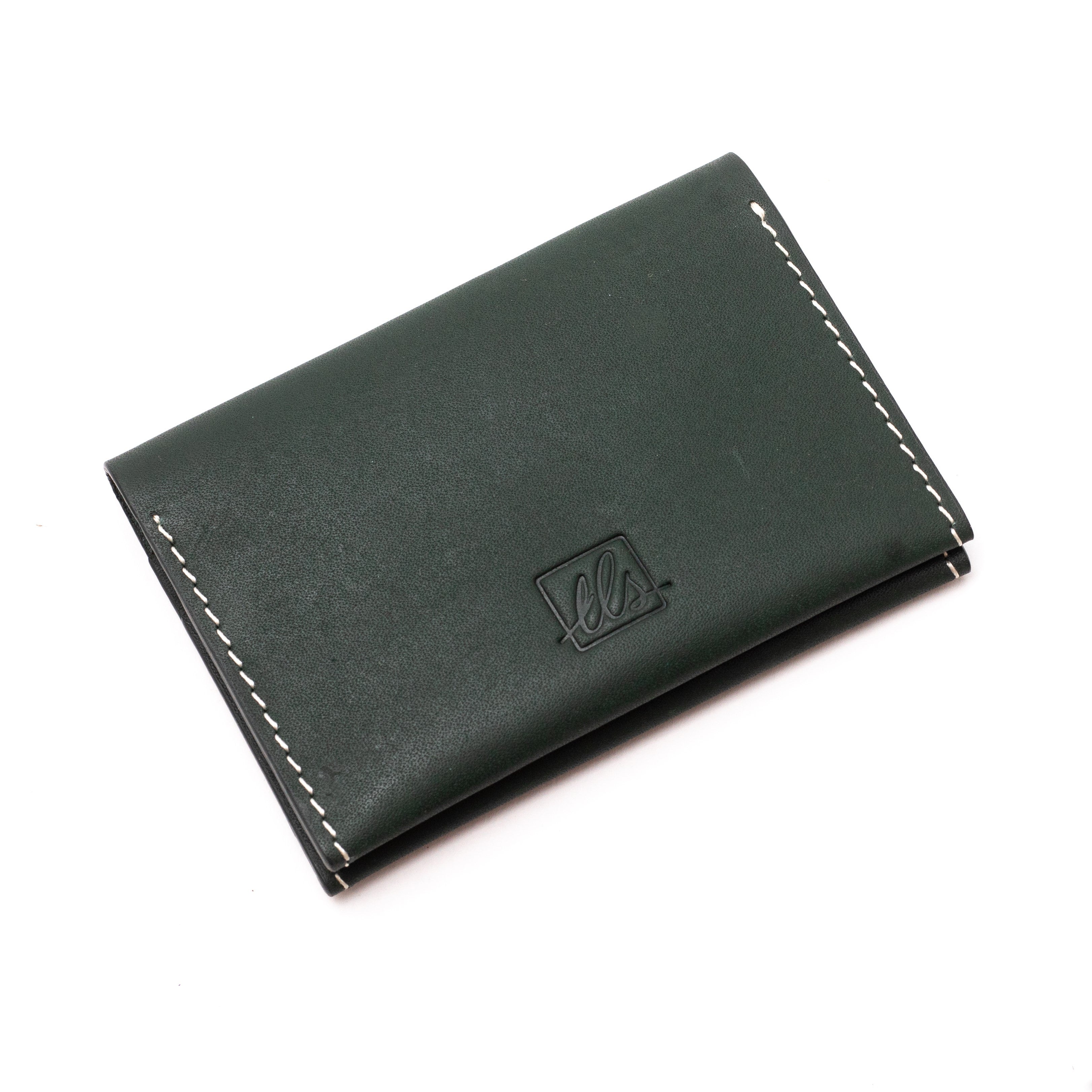 A closed dark green  bi-fold credit card holder with visible stitching and a embossed logo on the front of the leather story