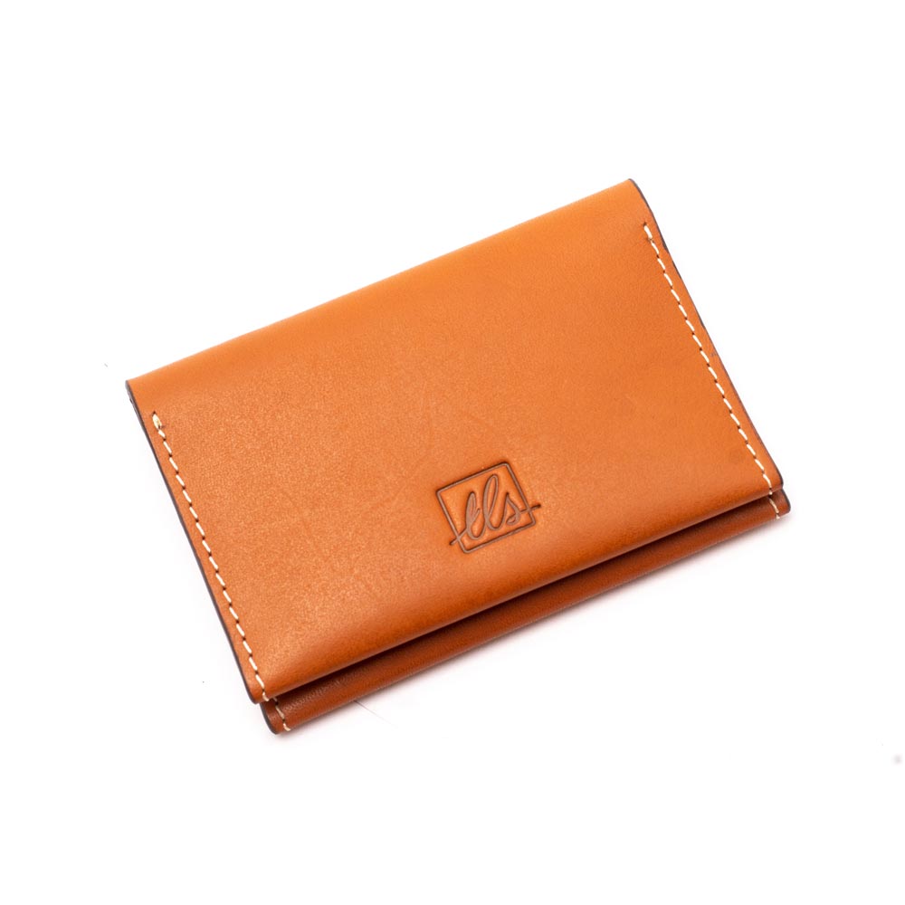 A closed mocha brown bi-fold credit card holder with visible stitching and a embossed logo on the front of the leather story